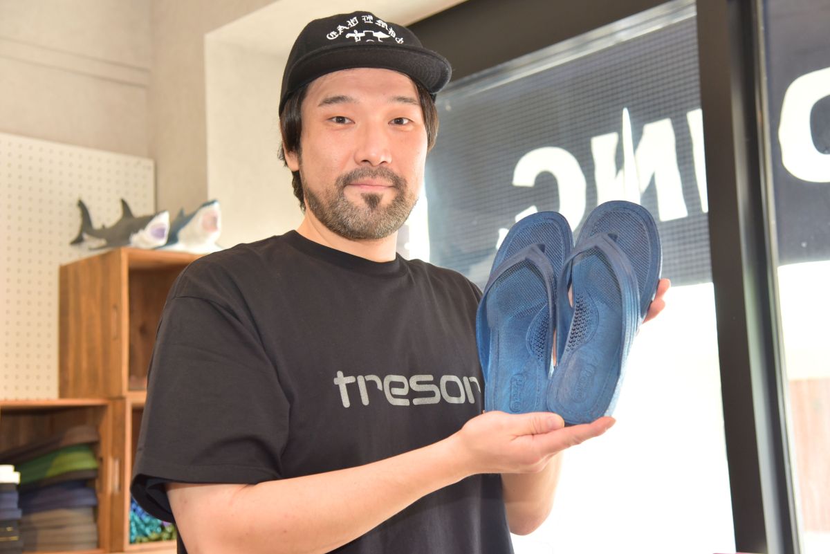 「湘南ネイビー」のギョサンを手に話す下垣さん